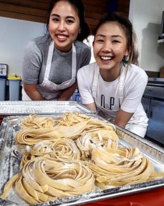 Smiling students and their pasta at cooking class Vancouver
